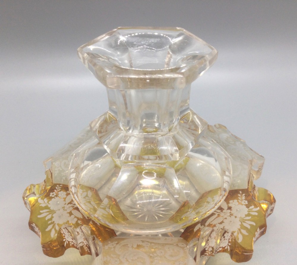 A Victorian cut crystal scent bottle with amber-stained floral engraving around the base, a faceted neck, and a tall pointed glass stopper. View VI