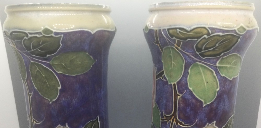 A matching pair of Royal Doulton Art Nouveau stoneware vases featuring stylized cream and soft pink rose motifs against a mottled cobalt blue background. View XIV