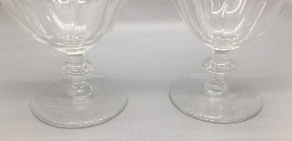 A pair of Edwardian clear cut lead crystal wine glasses with wheel-engraved leaf bands and vertical facet cuts. View III