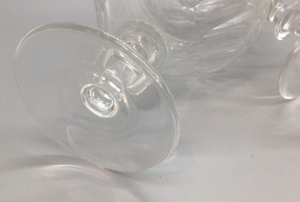 A pair of Edwardian clear cut lead crystal wine glasses with wheel-engraved leaf bands and vertical facet cuts. View V