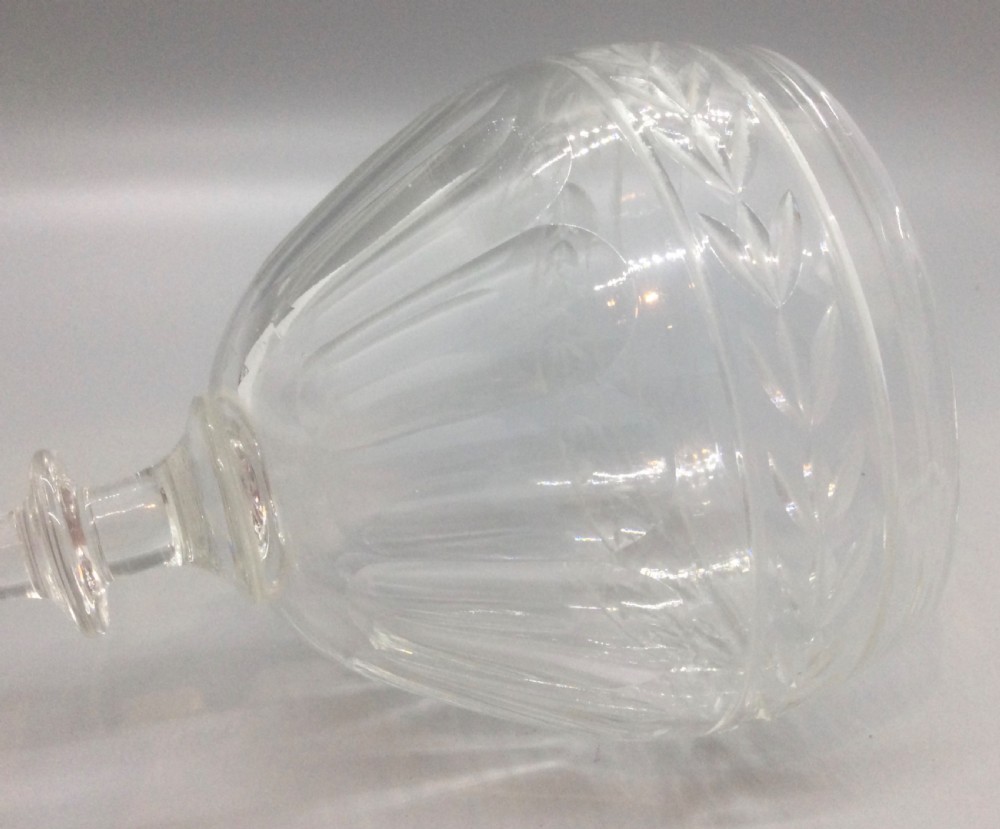 A pair of Edwardian clear cut lead crystal wine glasses with wheel-engraved leaf bands and vertical facet cuts. View VI