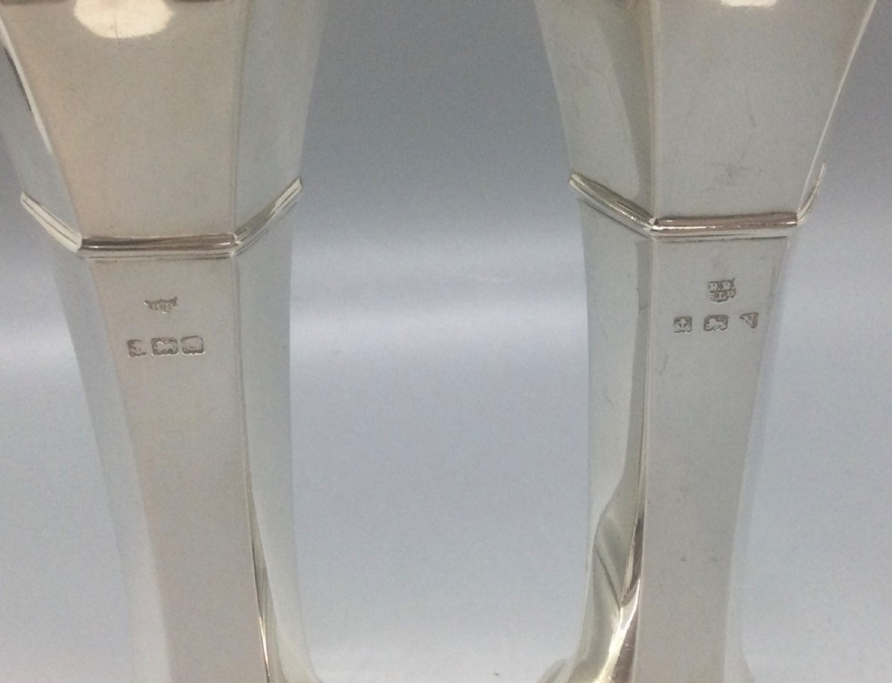 A pair of slender Art Deco sterling silver vases featuring faceted octagonal bodies, flared scalloped rims, and stepped pedestal bases. View V