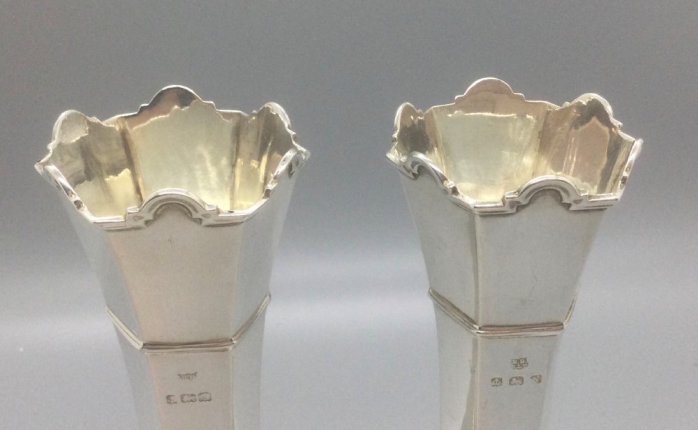 A pair of slender Art Deco sterling silver vases featuring faceted octagonal bodies, flared scalloped rims, and stepped pedestal bases. View VI