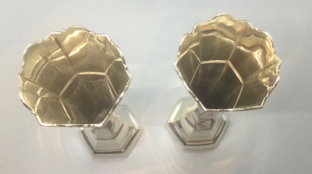 A pair of slender Art Deco sterling silver vases featuring faceted octagonal bodies, flared scalloped rims, and stepped pedestal bases. View VIII