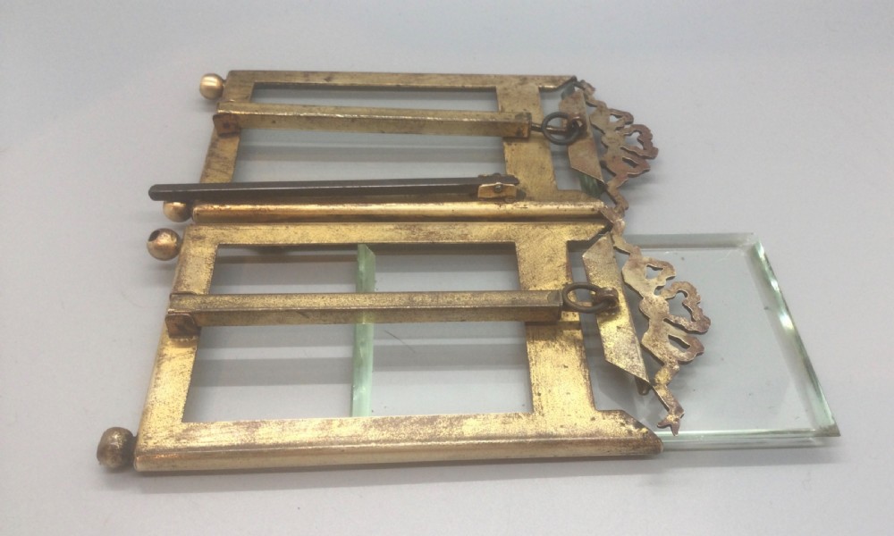 A late 19th-century French double photo frame made of gilt metal with ribbon cresting, bevelled glass, and ball feet. View XI