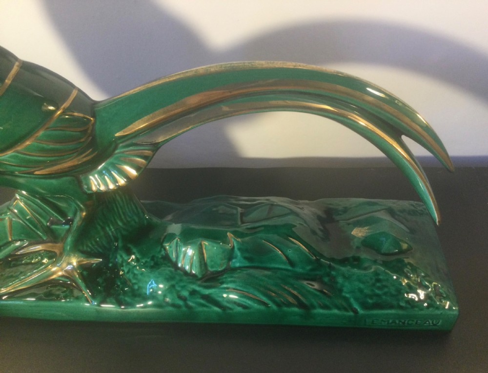 A stylised Art Deco green glazed ceramic pheasant figurine featuring fine gold line details and an extended sweeping tail resting on an integrated base. View III