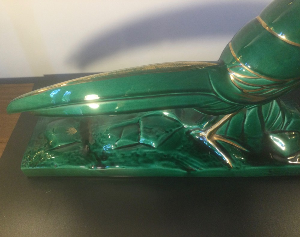 A stylised Art Deco green glazed ceramic pheasant figurine featuring fine gold line details and an extended sweeping tail resting on an integrated base. View VI