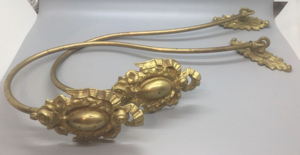 A pair of 19th-century French ormolu curtain tiebacks with long curved arms and ornamental floral backplates. View IV