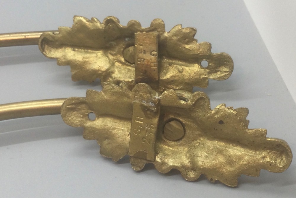 A pair of 19th-century French ormolu curtain tiebacks with long curved arms and ornamental floral backplates. View VII