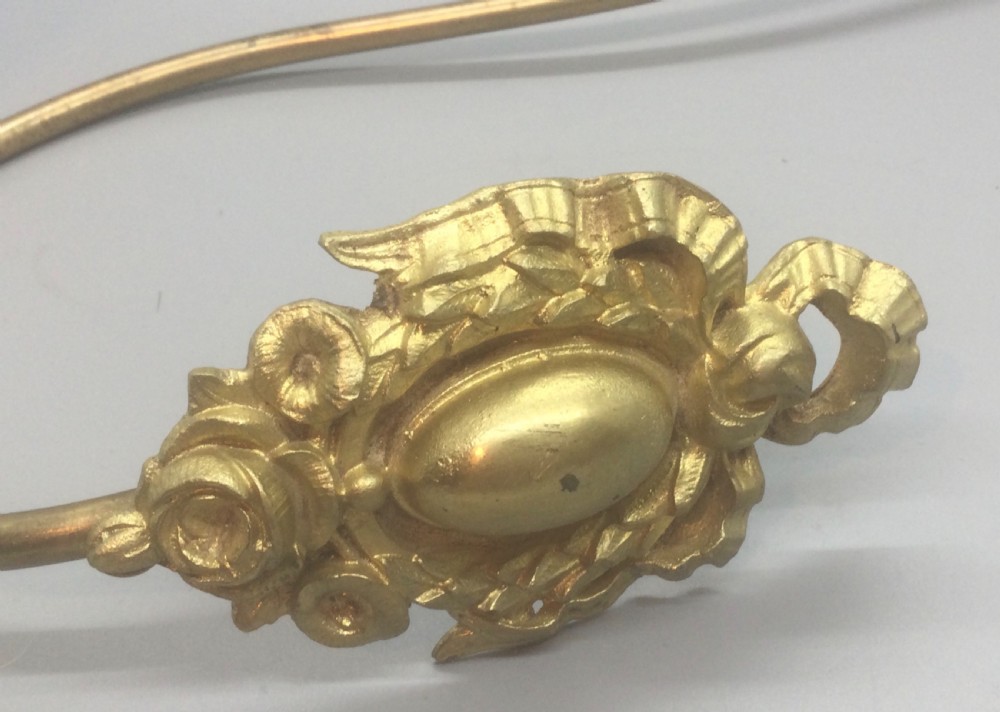 A pair of 19th-century French ormolu curtain tiebacks with long curved arms and ornamental floral backplates. View VIII