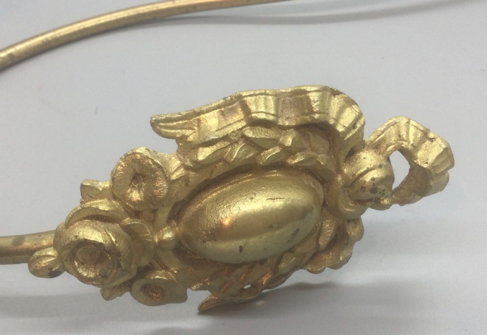 A pair of 19th-century French ormolu curtain tiebacks with long curved arms and ornamental floral backplates. View IX
