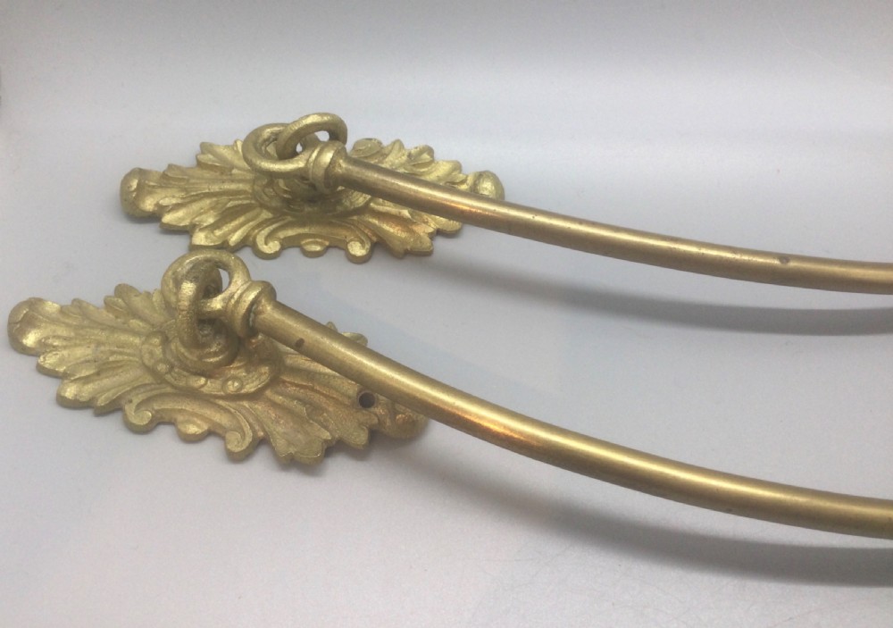 A pair of 19th-century French ormolu curtain tiebacks with long curved arms and ornamental floral backplates. View X