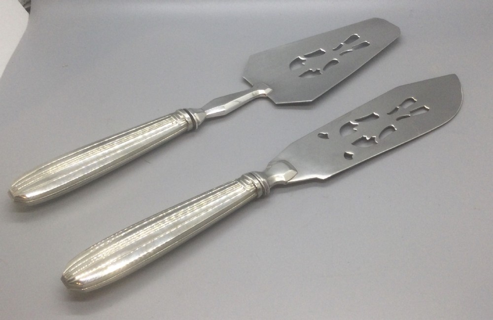 A pair of French silver-plated Art Deco cake servers with ribbed handles and pierced blades inside a white satin-lined presentation case. View II