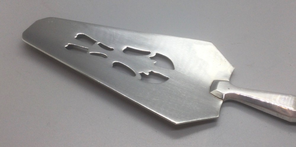 A pair of French silver-plated Art Deco cake servers with ribbed handles and pierced blades inside a white satin-lined presentation case. View IX