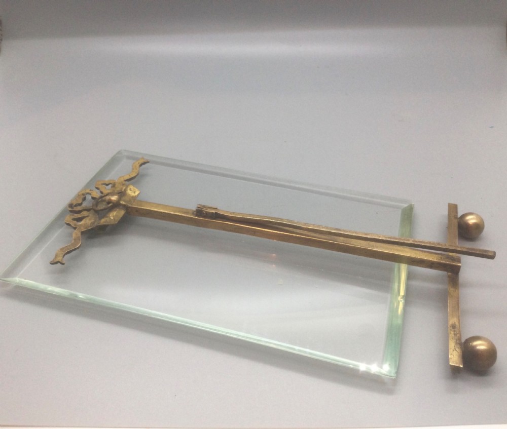 A late 19th-century French easel photo frame featuring thick bevelled glass, a ribbon bow top motif, spherical feet, and a gilded bronze framework. View VII