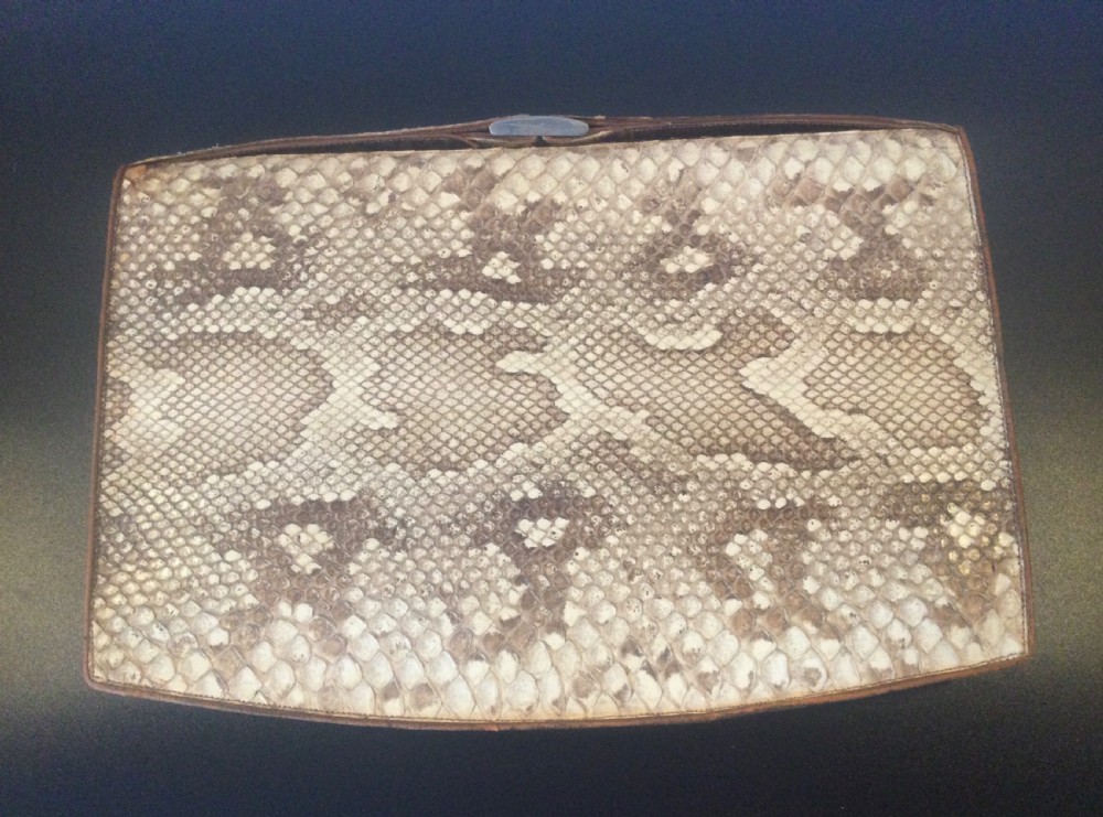 A 1930s rectangular python skin clutch bag featuring natural cream and brown mottled scales and a metal top clasp.