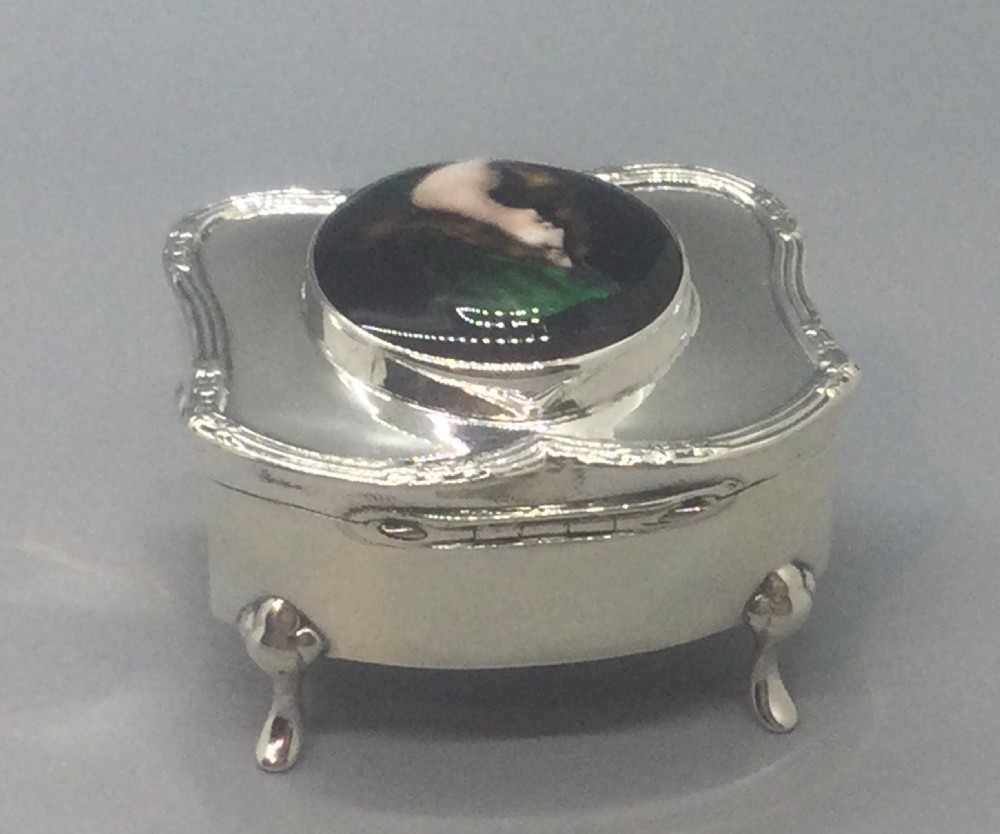 An Edwardian silver trinket box featuring a shaped rectangular body on four feet with a central circular hand-painted enamel plaque depicting a woman in profile wearing green. View IV