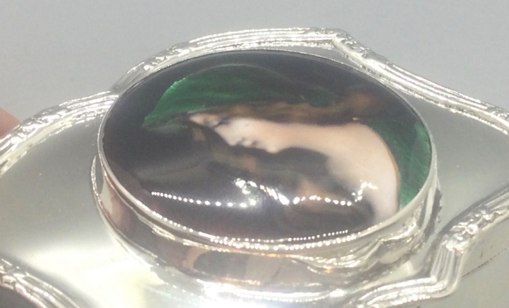 An Edwardian silver trinket box featuring a shaped rectangular body on four feet with a central circular hand-painted enamel plaque depicting a woman in profile wearing green. View XI