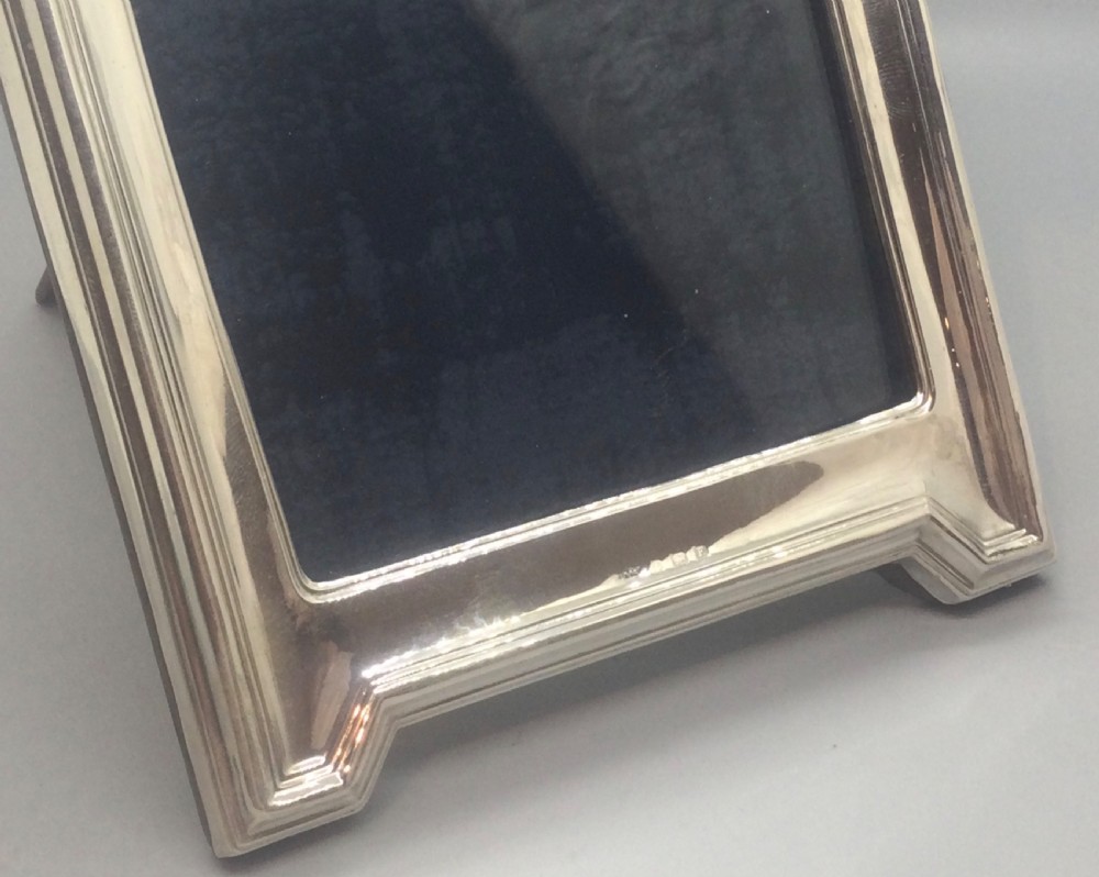 An Art Deco sterling silver picture frame featuring a stepped gabled top moulding and an easel back support. View VIII