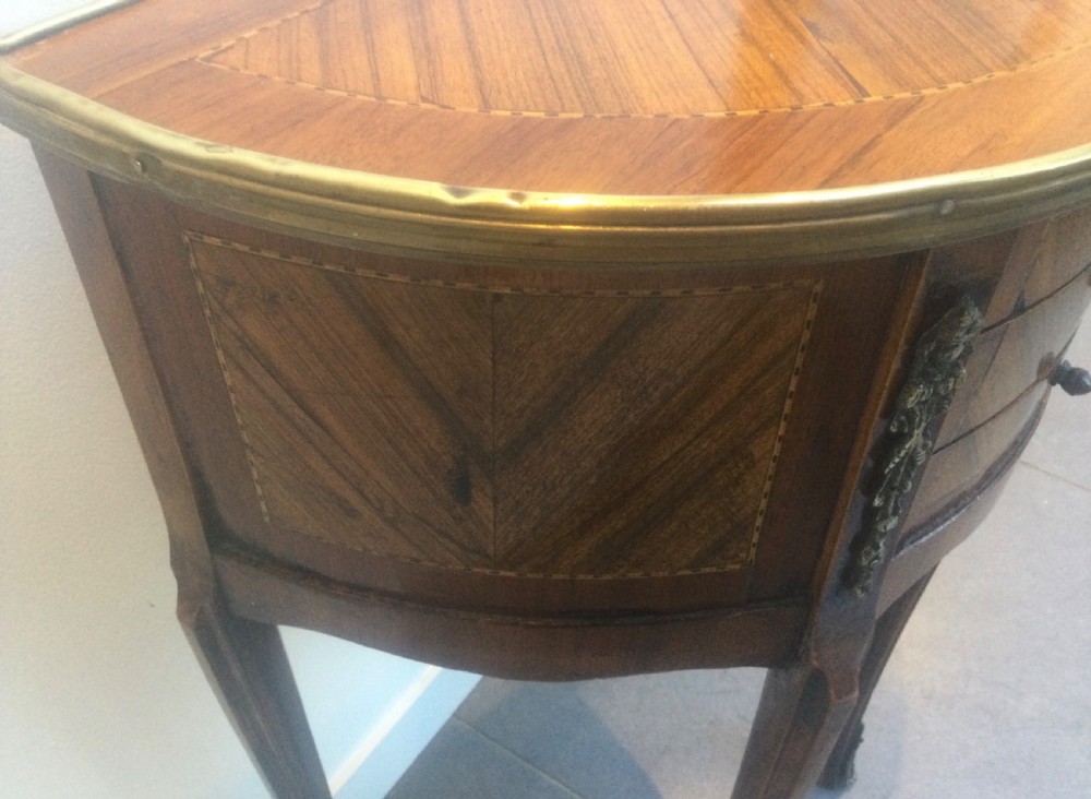 A late 19th-century French kingwood demi-lune console table featuring three drawers with geometric parquetry veneer, brass mounts, and long cabriole legs. View IV