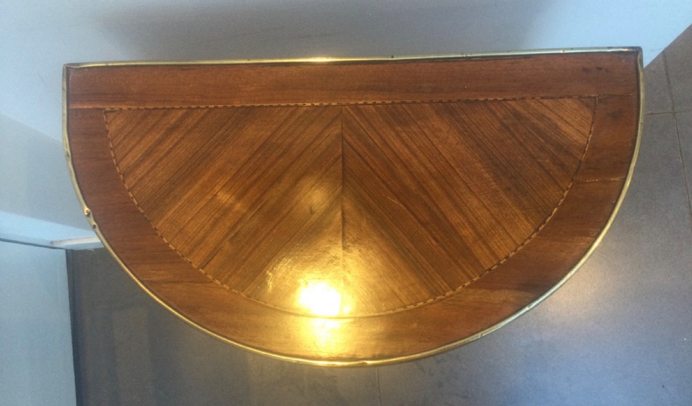 A late 19th-century French kingwood demi-lune console table featuring three drawers with geometric parquetry veneer, brass mounts, and long cabriole legs. View IX