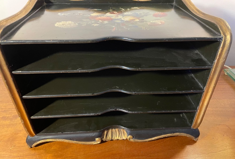 A black lacquered wooden desktop paper sorter featuring five tiered shelf slots, hand-painted floral decoration on top, and a carved gilt moulding frame. View VI
