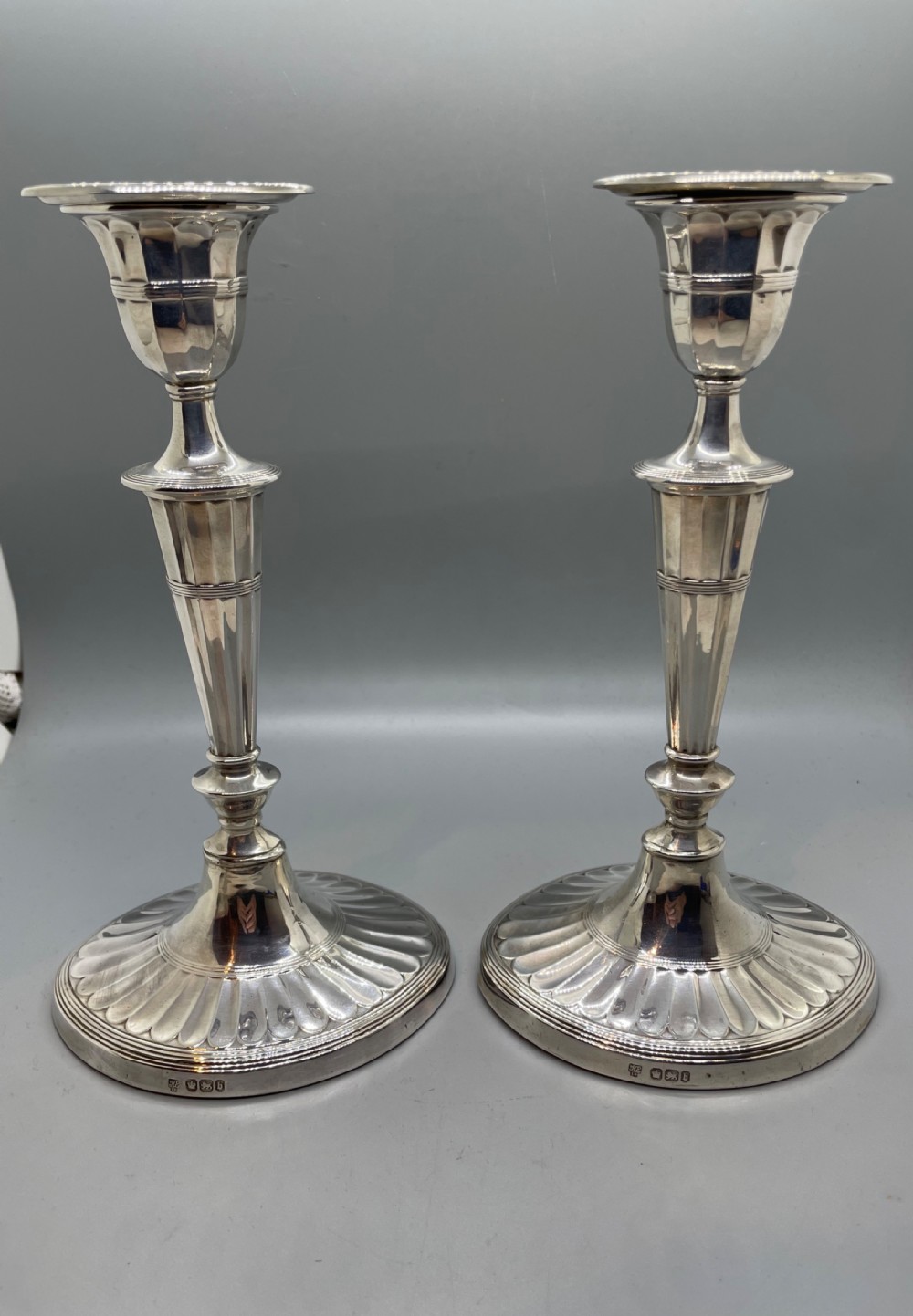 A pair of Victorian sterling silver candlesticks featuring fluted tapered shafts, sconces with reeded rims, and circular lobed bases. View III