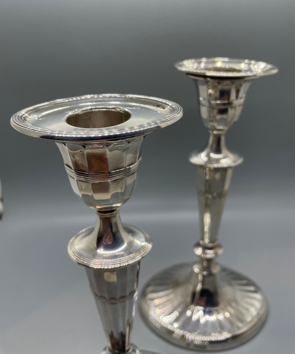 A pair of Victorian sterling silver candlesticks featuring fluted tapered shafts, sconces with reeded rims, and circular lobed bases. View IX