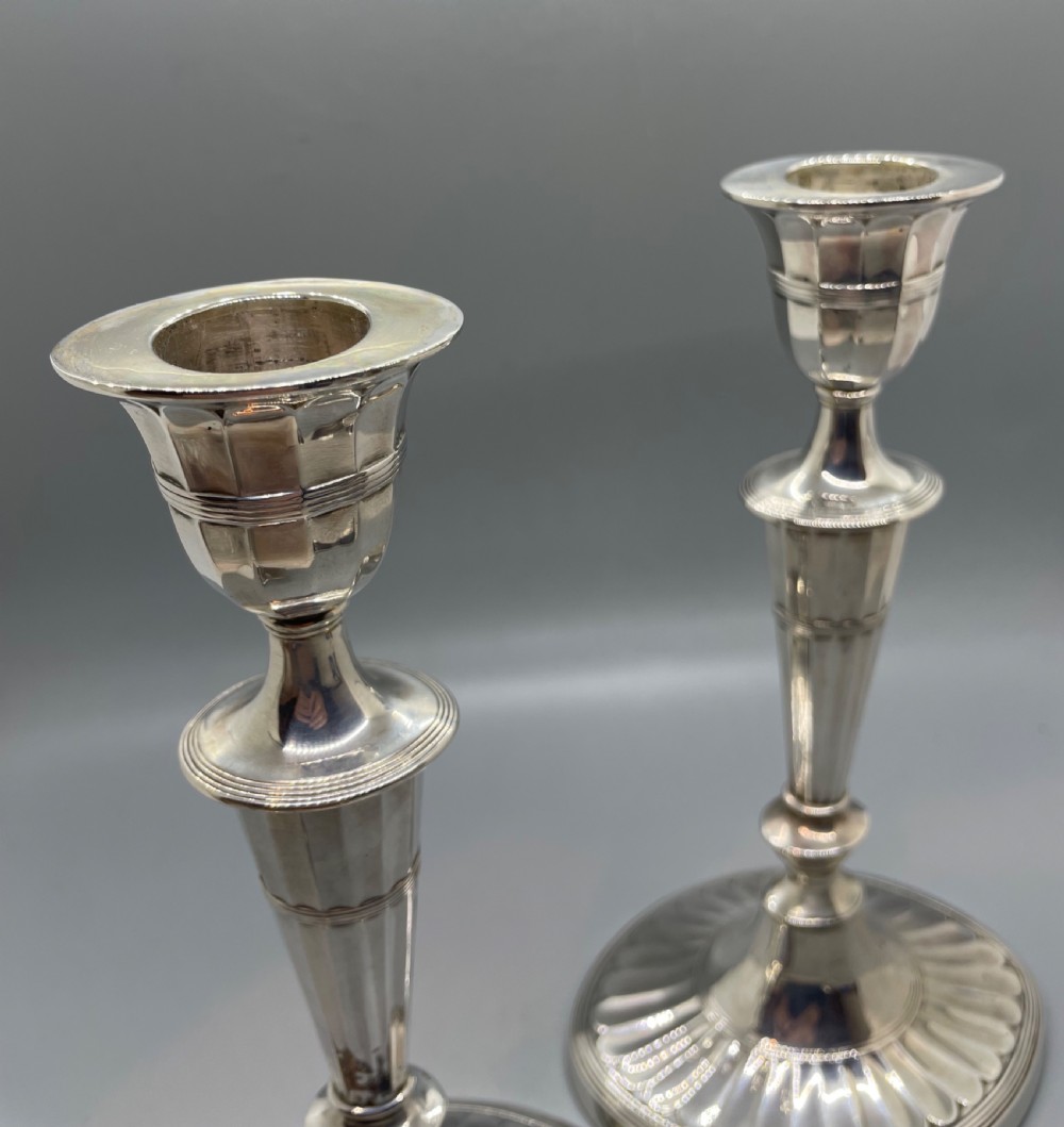 A pair of Victorian sterling silver candlesticks featuring fluted tapered shafts, sconces with reeded rims, and circular lobed bases. View XI