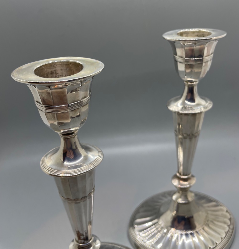 A pair of Victorian sterling silver candlesticks featuring fluted tapered shafts, sconces with reeded rims, and circular lobed bases. View XII