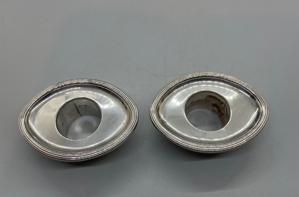 A pair of Victorian sterling silver candlesticks featuring fluted tapered shafts, sconces with reeded rims, and circular lobed bases. View XIV