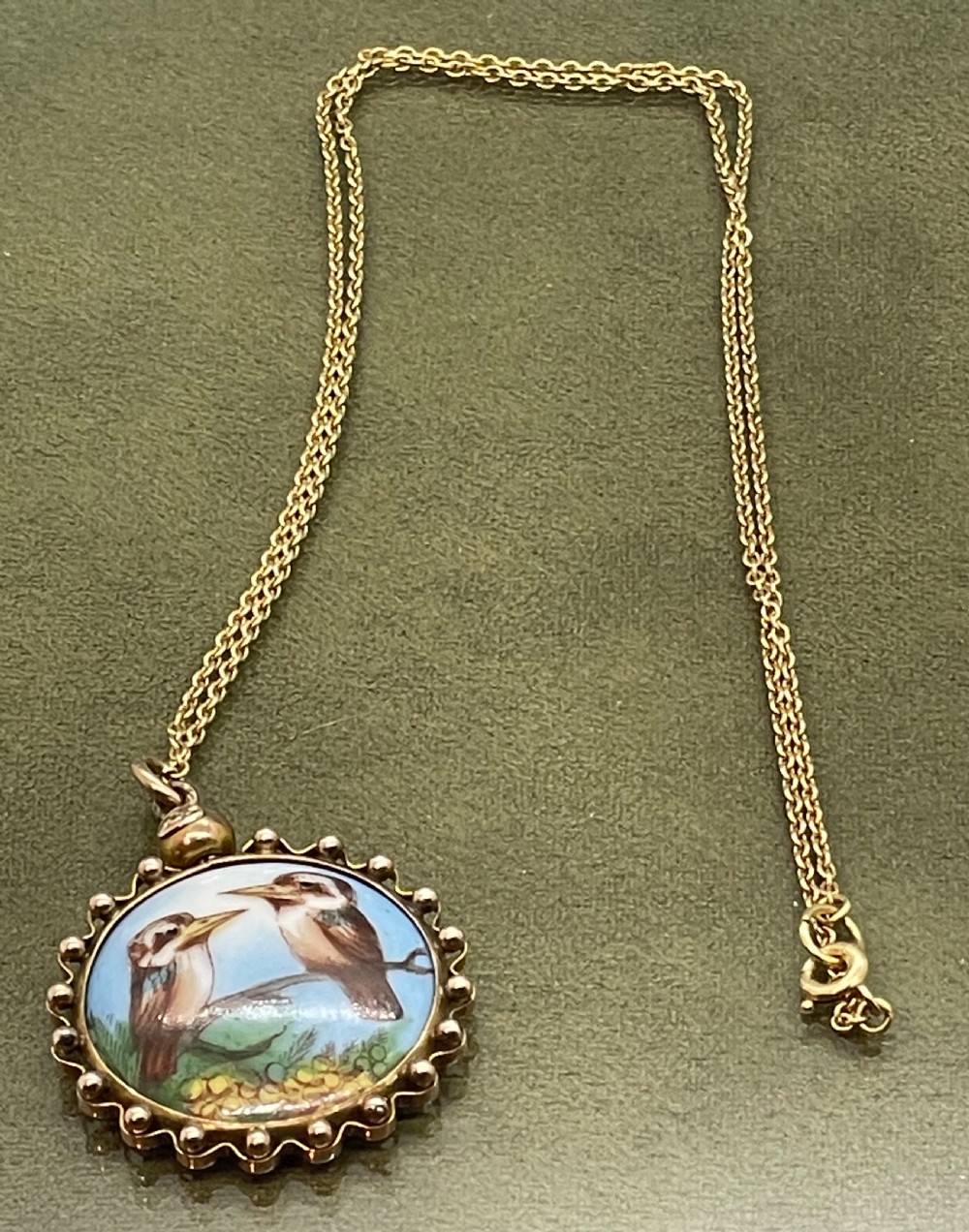 A circular late 19th-century 9ct gold pendant featuring a hand-painted enamel depiction of two kookaburras perched on a branch within a beaded border. View VII