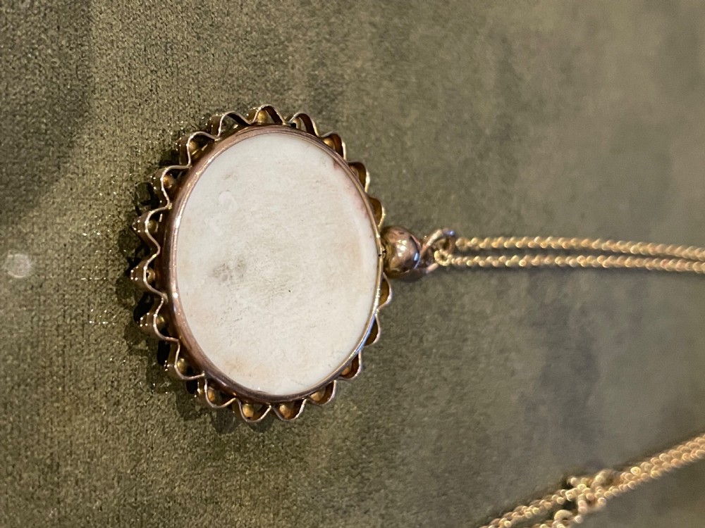 A circular late 19th-century 9ct gold pendant featuring a hand-painted enamel depiction of two kookaburras perched on a branch within a beaded border. View IX