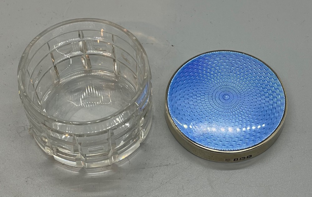 An Art Deco round clear glass vanity jar topped with a sterling silver rim and a blue engine-turned guilloche enamel lid. View III