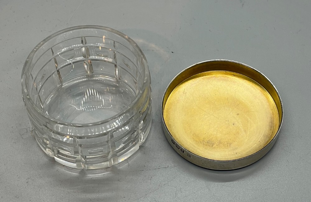 An Art Deco round clear glass vanity jar topped with a sterling silver rim and a blue engine-turned guilloche enamel lid. View IV