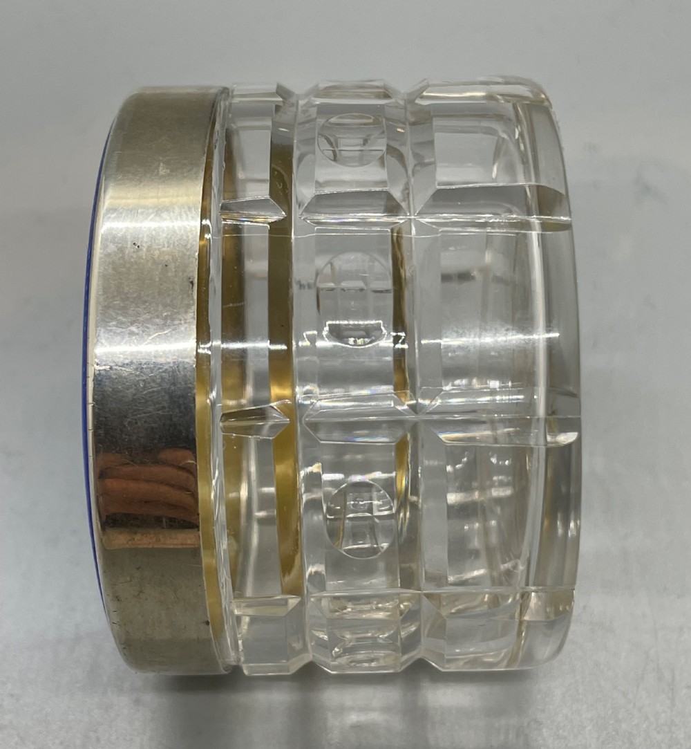 An Art Deco round clear glass vanity jar topped with a sterling silver rim and a blue engine-turned guilloche enamel lid. View VI