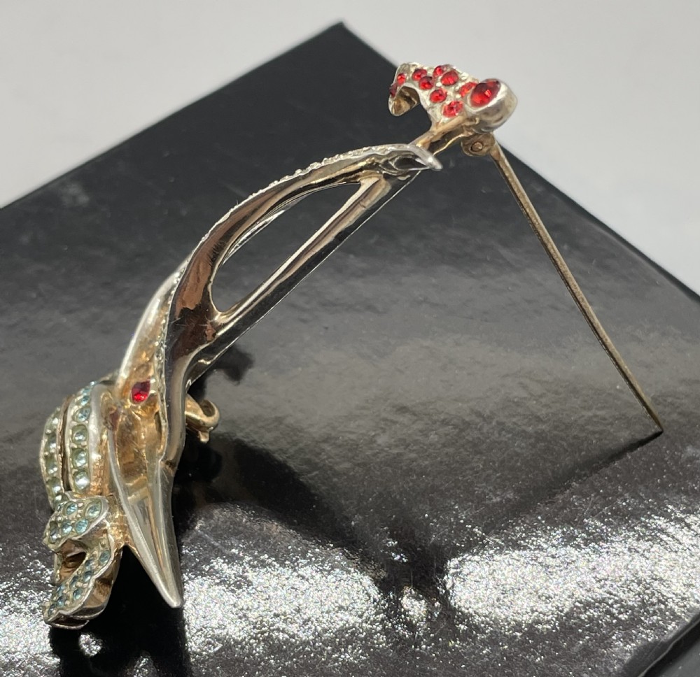 A 1940s sterling silver gilt brooch in the shape of a sailing yacht set with clear, light blue, and red rhinestones. View III