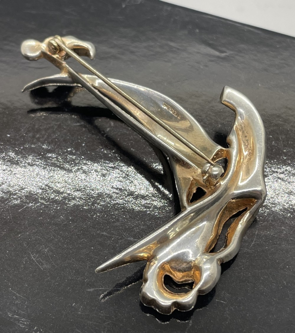 A 1940s sterling silver gilt brooch in the shape of a sailing yacht set with clear, light blue, and red rhinestones. View VI