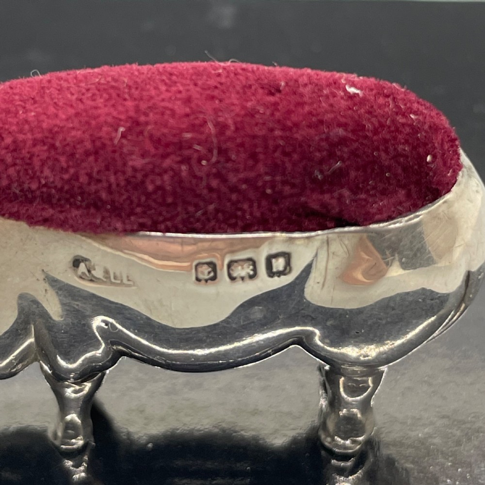 An Edwardian sterling silver pin cushion modelled in the shape of a standing pig with a red velvet pad on its back. View V