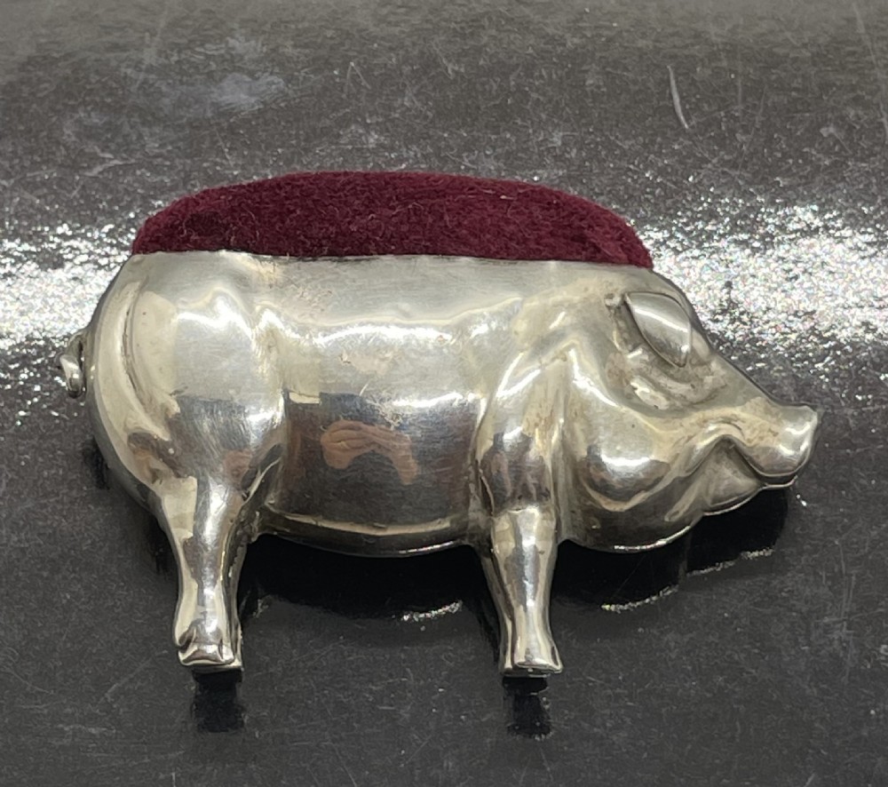 An Edwardian sterling silver pin cushion modelled in the shape of a standing pig with a red velvet pad on its back. View VIII