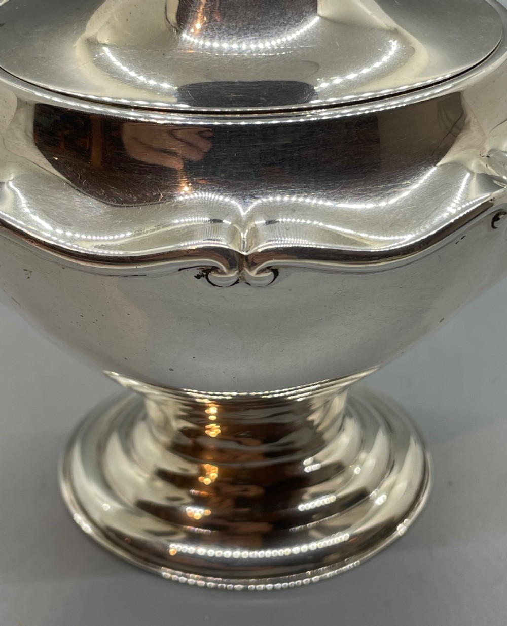 A George V sterling silver tea caddy with a lobed pedestal body, fitted lid, and a dark wooden finial. View X