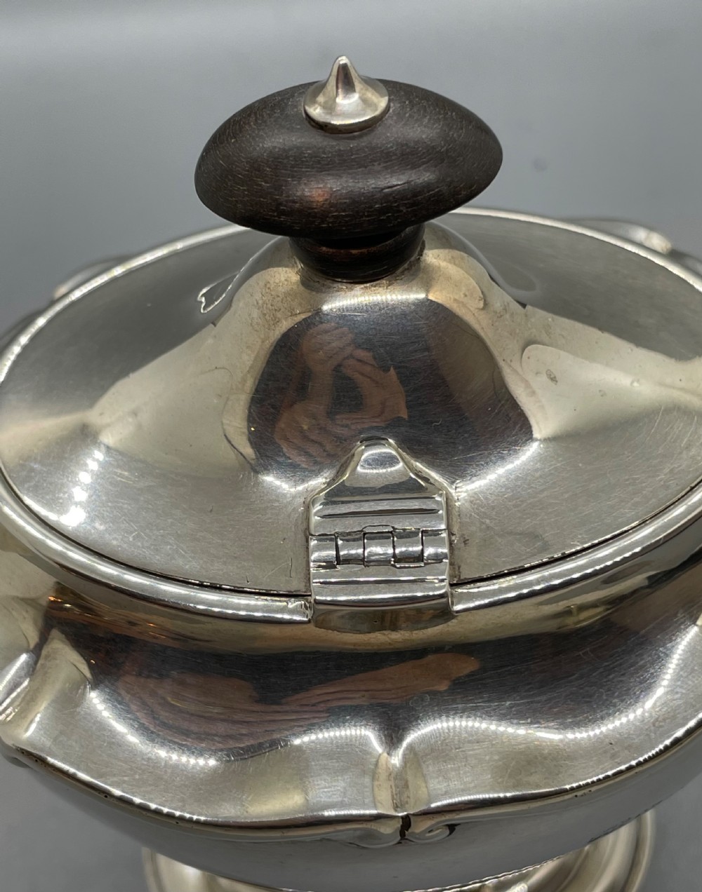 A George V sterling silver tea caddy with a lobed pedestal body, fitted lid, and a dark wooden finial. View XI