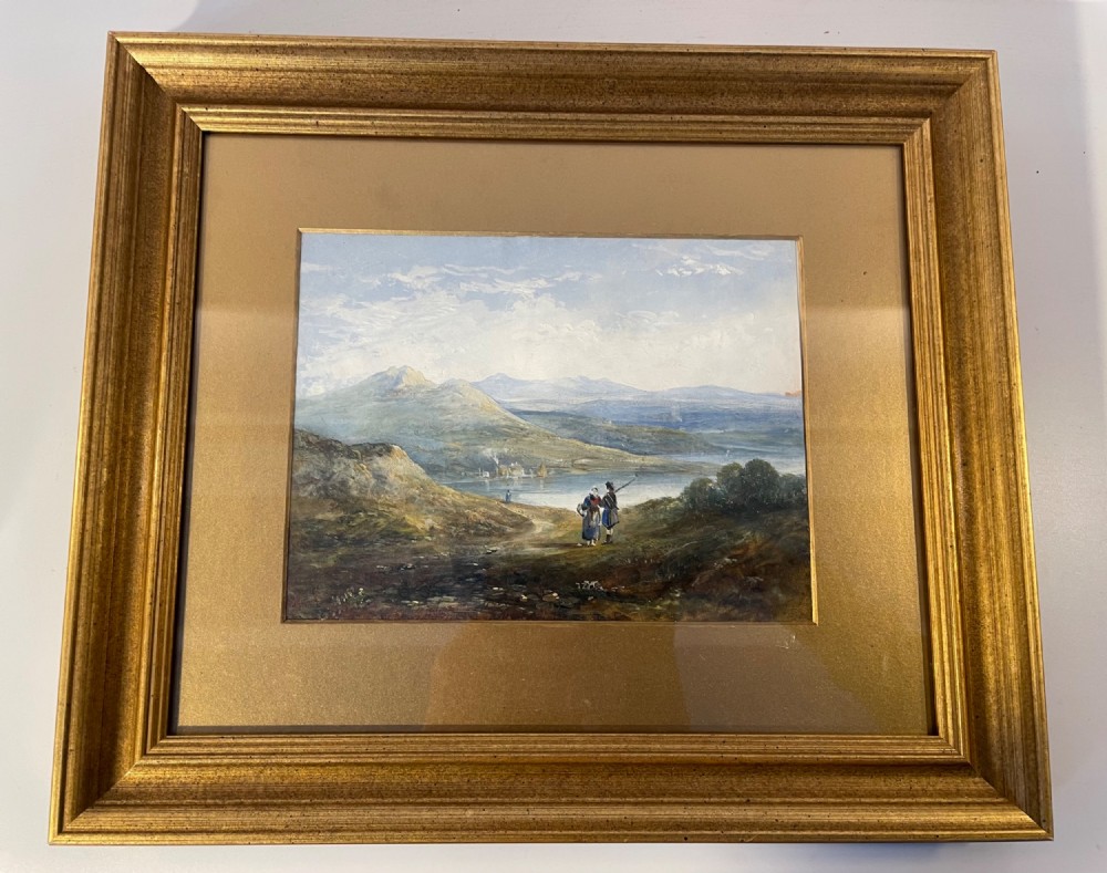 A 19th-century oil painting on panel depicting a mountainous landscape with figures near a body of water, set within a moulded gilded frame.