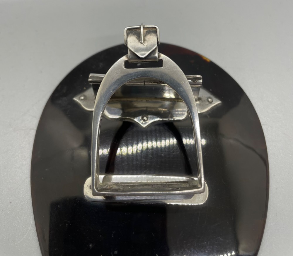 An Edwardian sterling silver letter clip styled as an equestrian stirrup on a smooth dark tortoiseshell base. View VIII