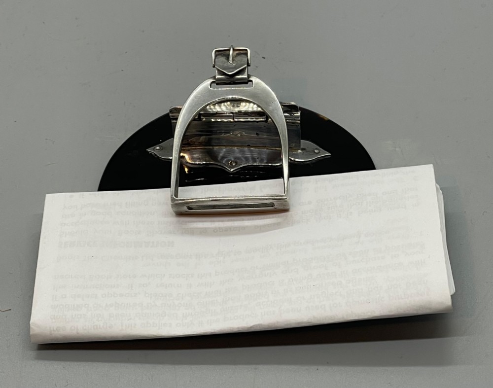 An Edwardian sterling silver letter clip styled as an equestrian stirrup on a smooth dark tortoiseshell base. View XII