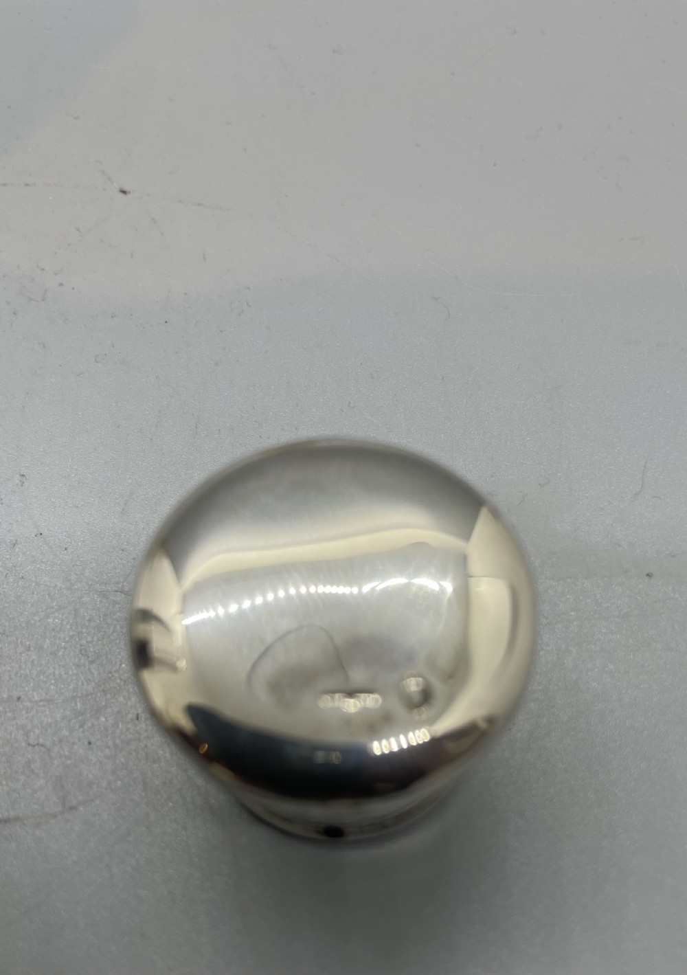 A Victorian glass spirit flask featuring a faceted clear glass upper section, a silver collar with cap, and a detachable silver base cup. View VII