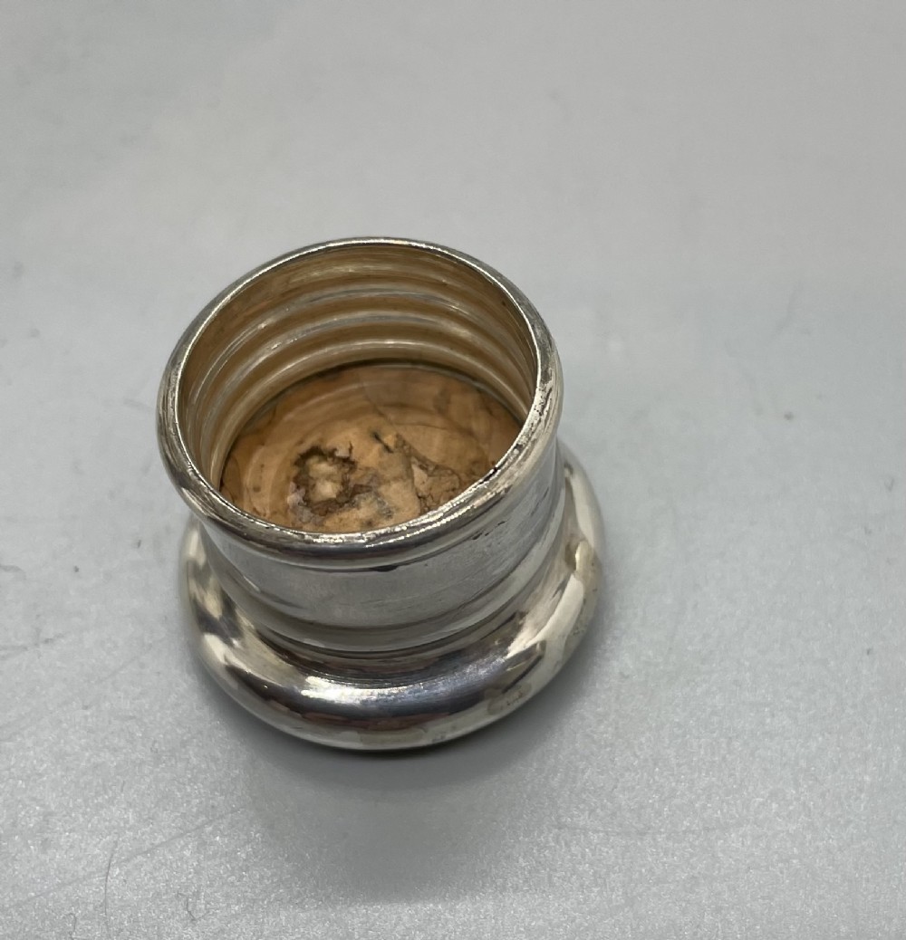 A Victorian glass spirit flask featuring a faceted clear glass upper section, a silver collar with cap, and a detachable silver base cup. View VIII