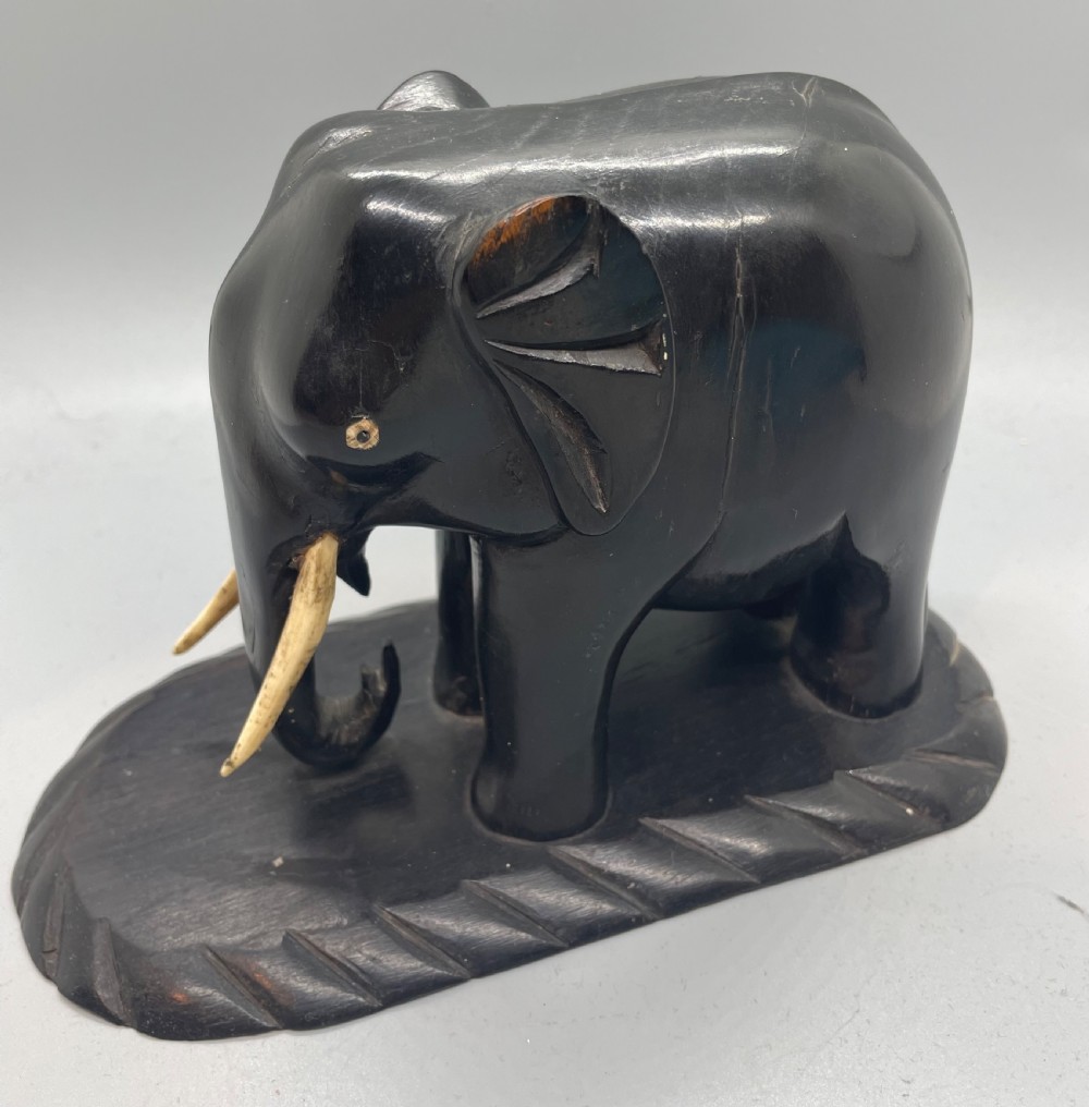 A pair of hand-carved dark wood elephant bookends from the Art Deco period, featuring light-coloured inlaid tusks and carved rope-twist edges on the bases. View VII