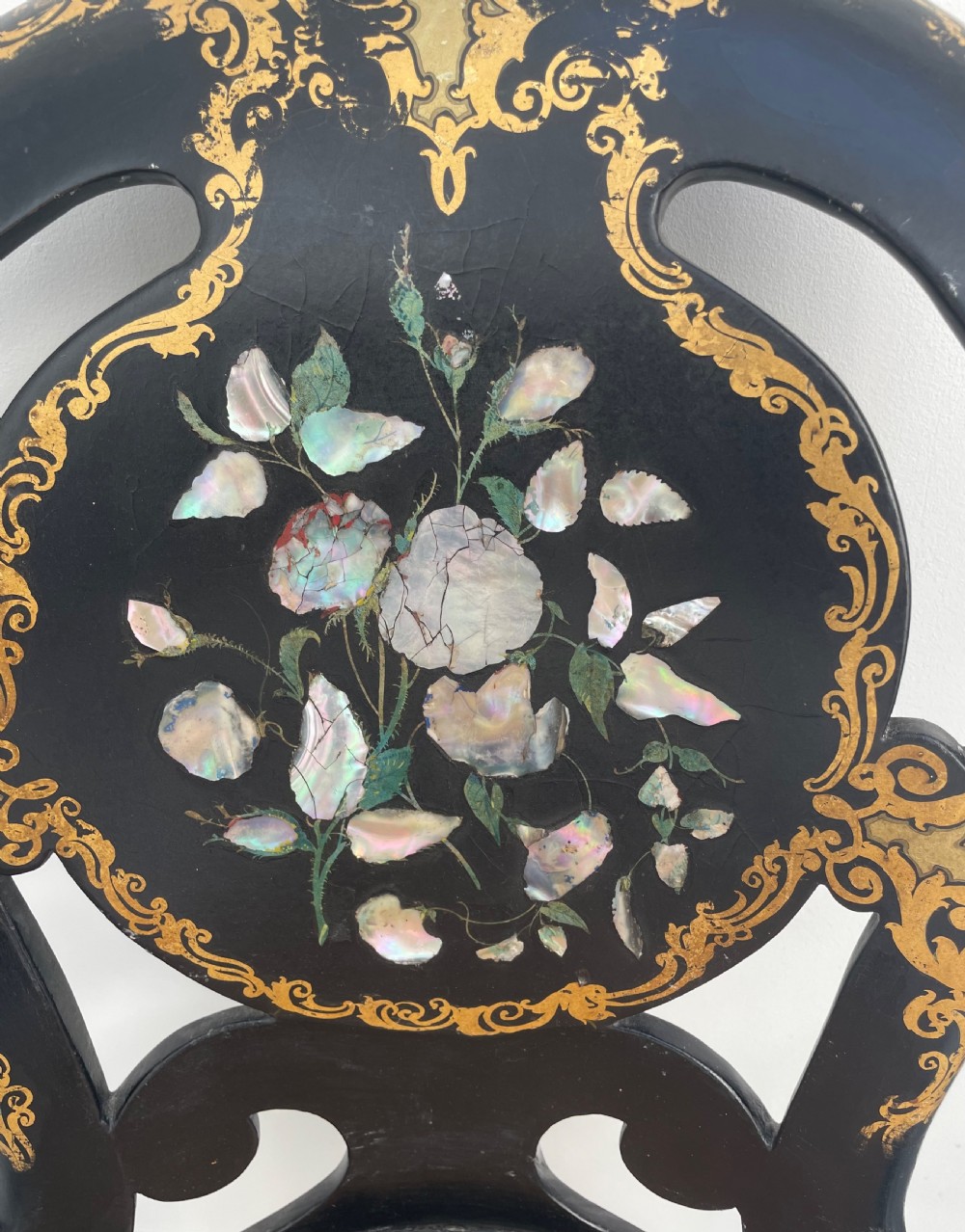 A Victorian ebonised side chair featuring floral mother-of-pearl inlays, gold leaf scrollwork decoration, a shaped back rest, cabriole front legs, and a woven cane seat. View III