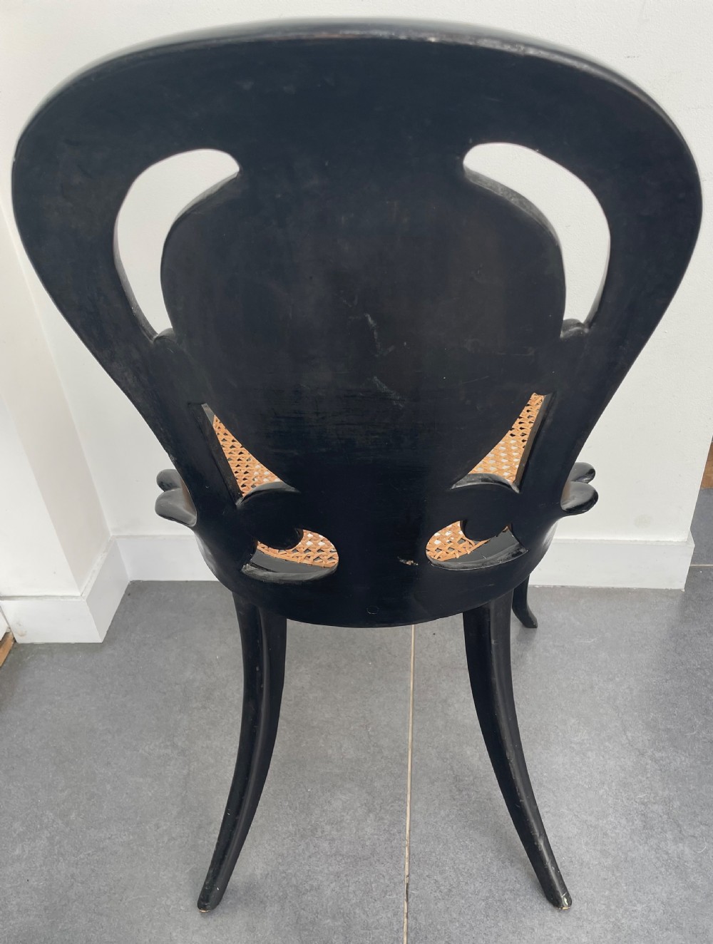 A Victorian ebonised side chair featuring floral mother-of-pearl inlays, gold leaf scrollwork decoration, a shaped back rest, cabriole front legs, and a woven cane seat. View VII